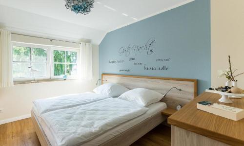 a bedroom with a bed and a table and a window at Haus Seeschwalbe in Ahrenshoop