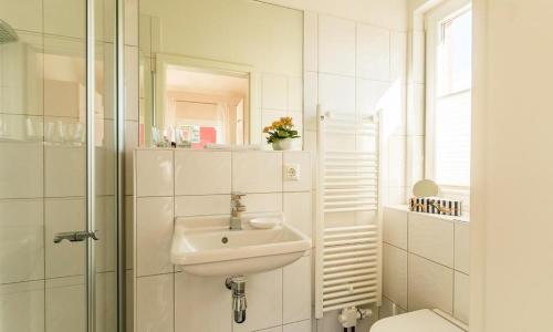 een witte badkamer met een wastafel en een douche bij Meertraum in Ahrenshoop
