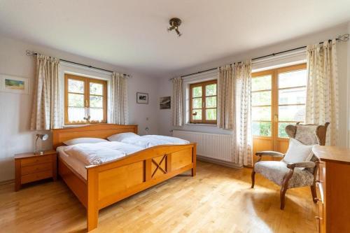 Schlafzimmer mit einem Bett, einem Stuhl und Fenstern in der Unterkunft Ahrenshooper Landhaus 01 in Ahrenshoop