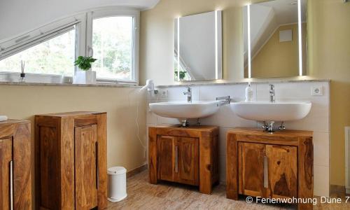 a bathroom with two sinks and a mirror at Düne 7 in Dierhagen