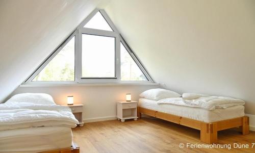 two beds in a room with two windows at Düne 7 in Dierhagen