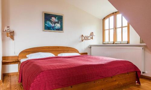 1 dormitorio con 1 cama grande con manta roja en Ahrenshooper Landhaus 04, en Ahrenshoop