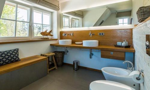 een badkamer met 2 wastafels en een toilet bij Freischwimmer in Wieck