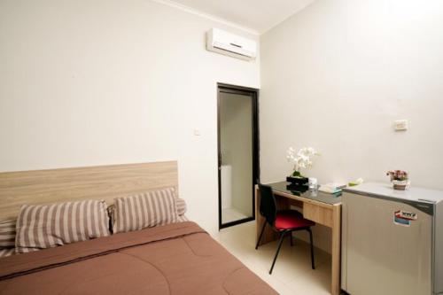 1 dormitorio con cama, escritorio y mesa en DPARAGON UPN, en Yogyakarta