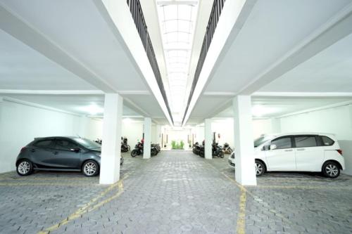 Un estacionamiento con dos coches estacionados en él en DPARAGON UPN, en Yogyakarta