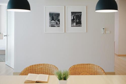 a dining room with a table and chairs and two lights at Palm Crescent Hua Hin in Cha Am