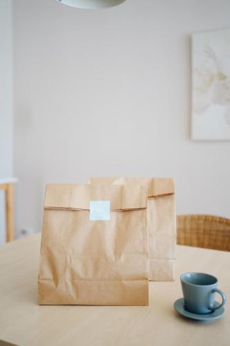 a brown paper bag sitting on a table with a coffee cup at Palm Crescent Hua Hin in Cha Am
