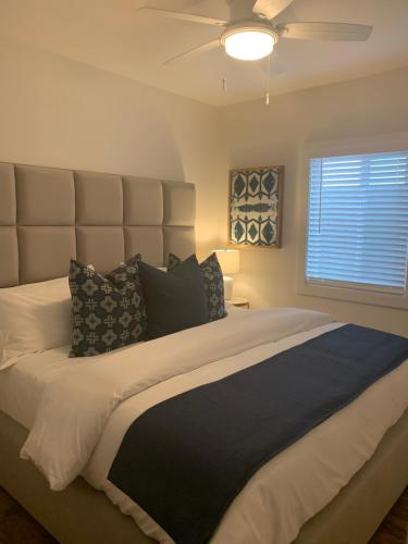 a bedroom with a large bed with a ceiling fan at Huntington Highlight - Pool, Patio, Close To Beach in Huntington Beach