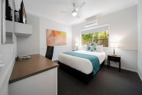 a white bedroom with a bed and a window at Roma Inland Motor Inn in Roma