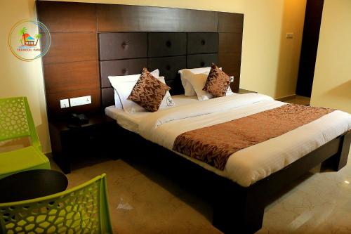 a bedroom with a large bed with a large headboard at Tranquil Park in Puducherry