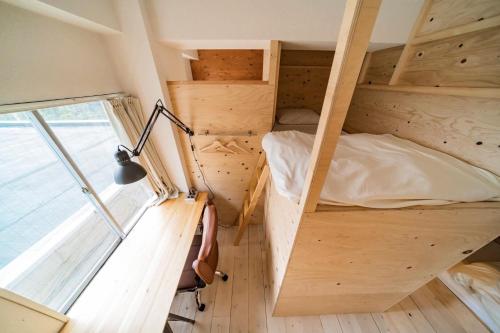 a tiny house with a bed and a lamp at ArtBar & GuestHouse ennova in Atami