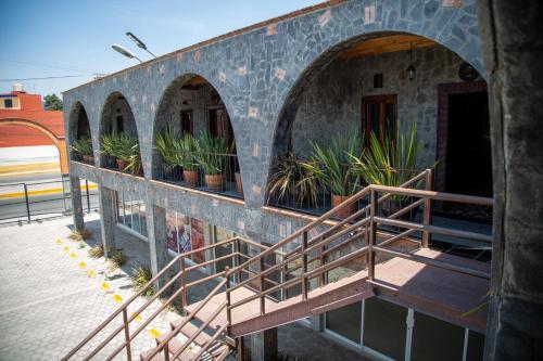 a building with stairs and potted plants on it at Hotel Vitorina Cholula in Cholula
