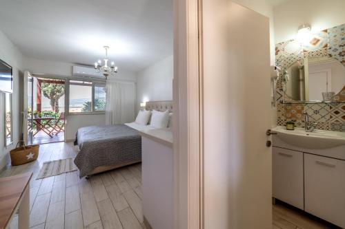 a bedroom with a bed and a bathroom with a sink at Holiday Village Kibbutz Mizra in Mizra‘