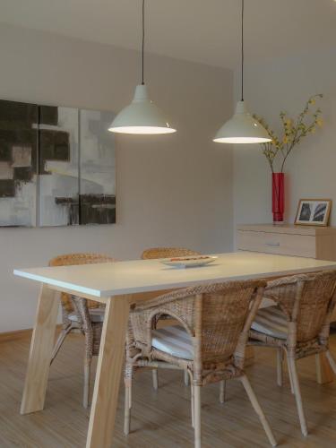 a dining room table with chairs and pendant lights at Palm Crescent Hua Hin in Cha Am