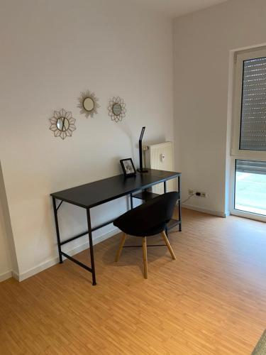 a black desk in a room with a chair at Deluxe Apartments Messe Flughafen in Leinfelden-Echterdingen