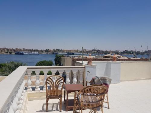 um grupo de cadeiras e mesas numa varanda em Nile Sunrise Flats em Luxor