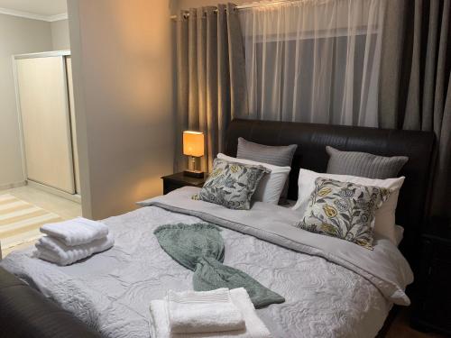 a bedroom with a bed with towels and pillows at Oasis Self-Catering in Swakopmund