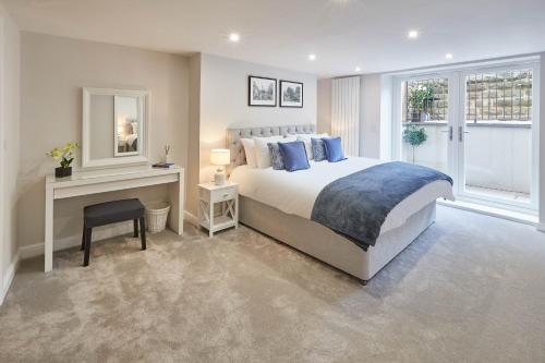 哈羅蓋特的住宿－Host & Stay - The Garden Apartment，一间卧室配有一张床、一张书桌和一个窗户。