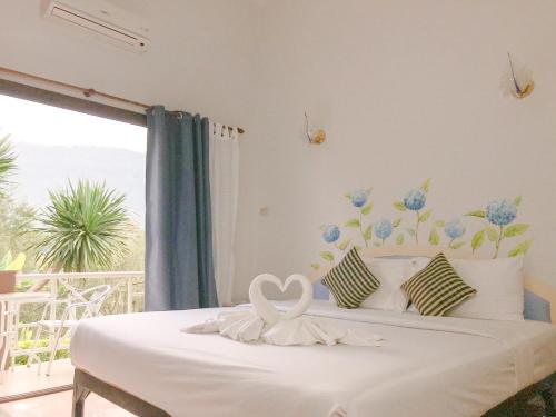 a bedroom with a bed with a heart decoration on it at Phurua Bussaba Resort & Spa in Loei