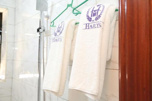 a group of towels hanging on a rack in a bathroom at Harts Motel in Kampala