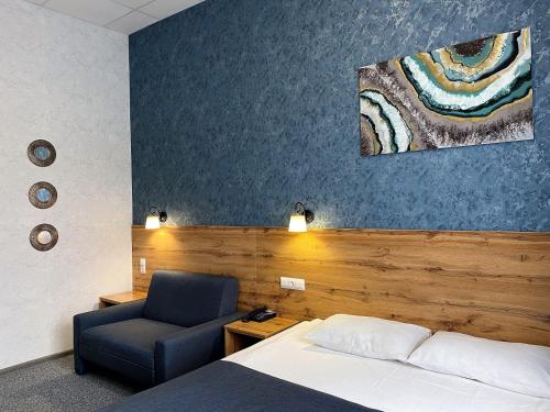 ein Hotelzimmer mit einem Bett und einem Stuhl in der Unterkunft Virginia Hotel in Joschkar-Ola