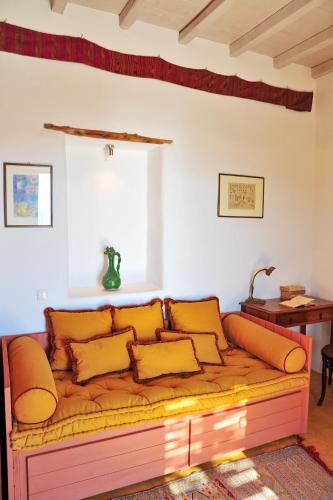 a couch in a living room with yellow pillows at Alonistria in Órmos Aiyialís