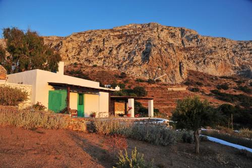 a house with a mountain in the background at Alonistria in Órmos Aiyialís