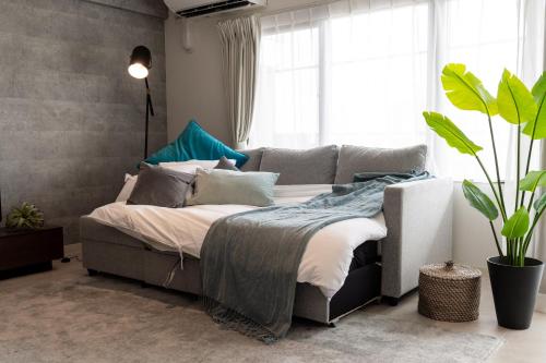 a bedroom with a bed and a large window at Little Santa in Ginowan