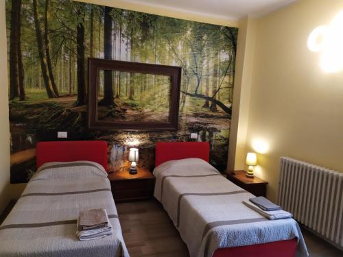 two beds in a room with a painting on the wall at B&B Country House Crema in Crema