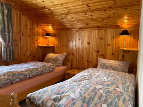 a bedroom with two beds in a log cabin at Chalet Michele Alpage in Les Collons