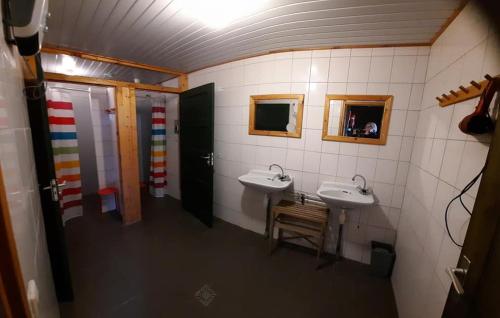 a bathroom with two sinks and a wooden chair at 't Peelhuisje in Kronenberg