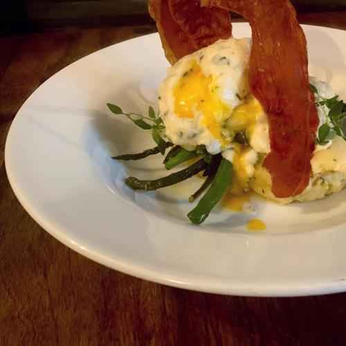 a white plate with an egg with bacon and asparagus at Tottington Manor Hotel in Henfield
