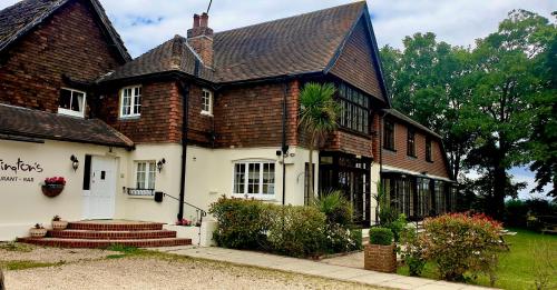 a white house with a brown roof at Tottington Manor Hotel in Henfield