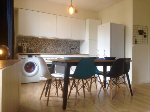 eine Küche mit einem Tisch und Stühlen sowie einer Waschmaschine in der Unterkunft Joli Appartement Le Gutenberg T2 4p Quartier Mirabeau Proche Gare in Tours