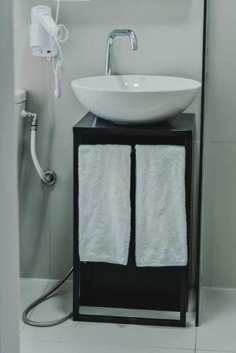 a bathroom with a sink and a white bowl at Atelier Boutique Hotel in Shkodër