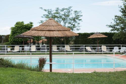 a straw umbrella next to a swimming pool at Appartamento Nonno Trulli in Stabbia