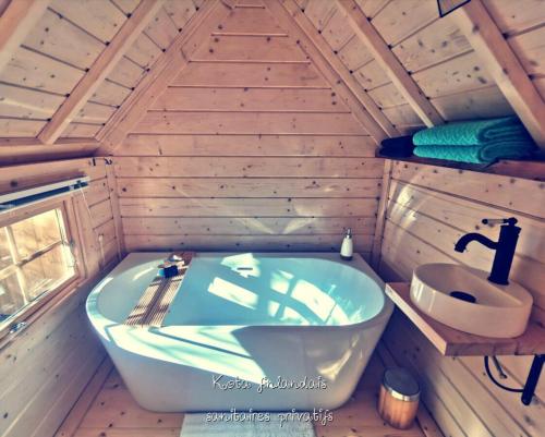 a bathroom with a tub and a sink in a cabin at Juste par hasard chambres d hôtes insolites à 140 m de la mer in Saint-Michel-Chef-Chef