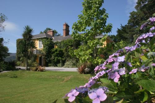 a house with pink flowers in the yard at Carrig Country House & Restaurant in Killorglin