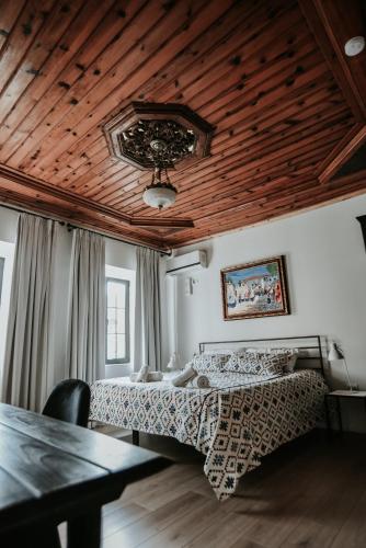 a bedroom with a bed and a wooden ceiling at Atelier Boutique Hotel in Shkodër
