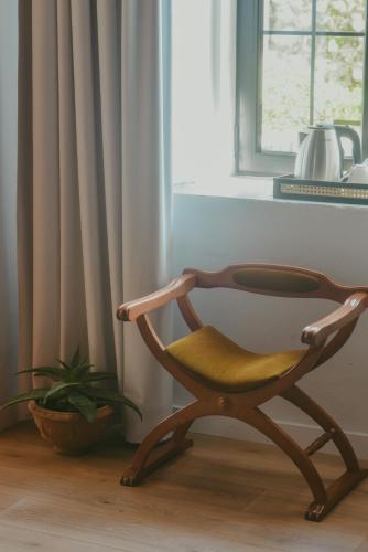 a wooden chair sitting in front of a window at Atelier Boutique Hotel in Shkodër