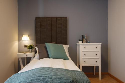 a bedroom with a bed and a white dresser and a bed sidx sidx sidx at Hotel Milano & Apartments in Miazzina