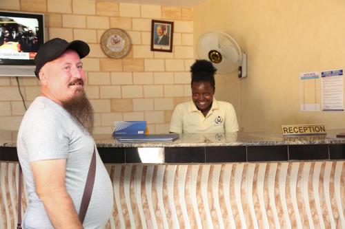 a man standing in front of a counter in a kitchen at Harts Motel in Kampala