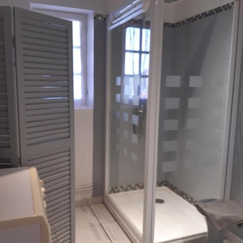 une salle de bain avec une douche avec une porte vitrée dans l'établissement Maison Le Chatelet, à Erquy