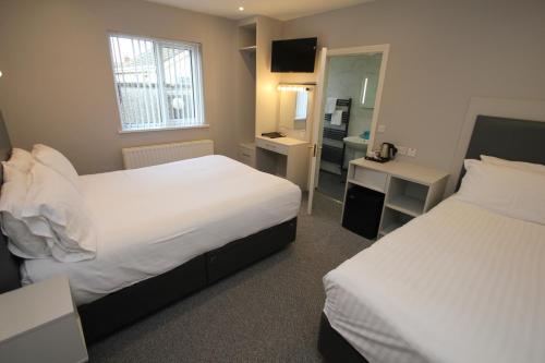 a hotel room with two beds and a bathroom at North Coast Motel in Portrush