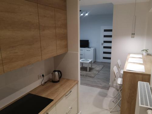 a kitchen with wooden cabinets and a counter top at Gwiazda Bemowa in Warsaw