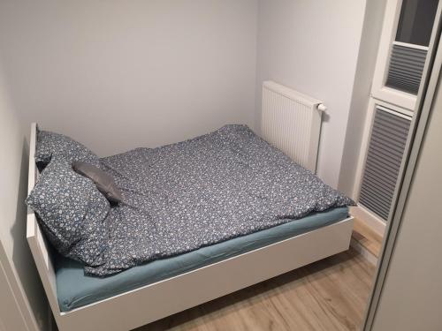 małe łóżko w małym pokoju z lustrem w obiekcie Gwiazda Bemowa w Warszawie