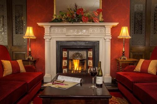 a living room with a fireplace and a table with wine glasses at The Great Northern Hotel in Bundoran