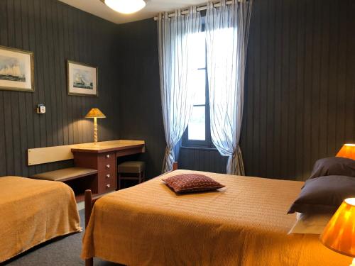 a bedroom with two beds and a window and a desk at Le Clos des Lys, Maison de Pays Raffinée Proche de la Mer, Linge Inclus in Saint-Georges-dʼOléron