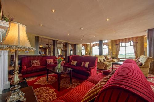 a living room with red furniture and a lamp at The Great Northern Hotel in Bundoran