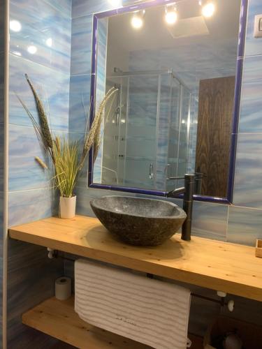 a bathroom with a stone sink and a mirror at La Luna in Aldeanueva del Camino